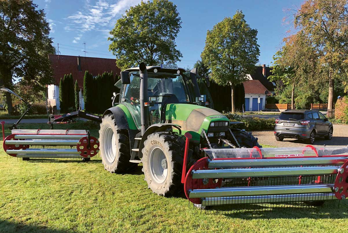 Traktor mit Gerät auf einer Wiese